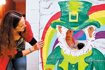 Four-year-old Adrianna Bionacci gets some encouragement from her mother, Stephanie Patrella, as through a leprechaun cut-out during the 13th Annual Celtic Festival of Arts and Spirituality at the Knights of Columbus Hall Friday. © 2011 Gallup Independent / Cable Hoover 